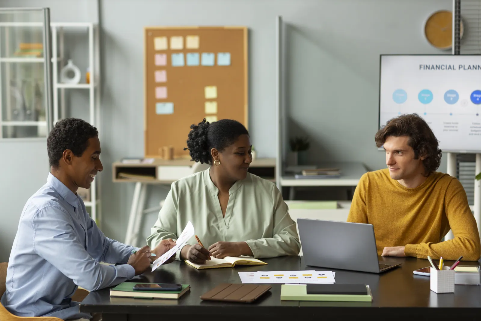 Team gathered around a table discussing a financial plan